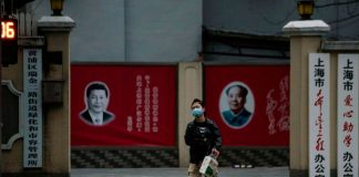 Rretratos del presidente chino Xi Jinping y el líder Mao Zedong en una calle de Shanghái