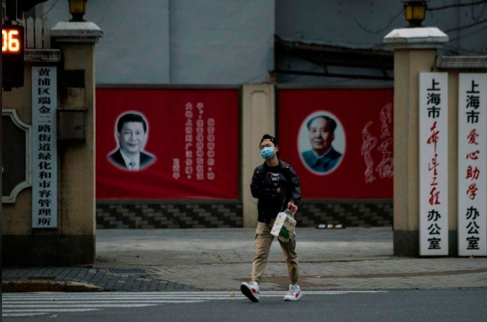 Rretratos del presidente chino Xi Jinping y el líder Mao Zedong en una calle de Shanghái