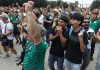 Aficionados celebran un gol en la tribuna mostrando los beneficios de la salud mental futbol al unirse en comunidad