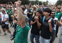 Aficionados celebran un gol en la tribuna mostrando los beneficios de la salud mental futbol al unirse en comunidad