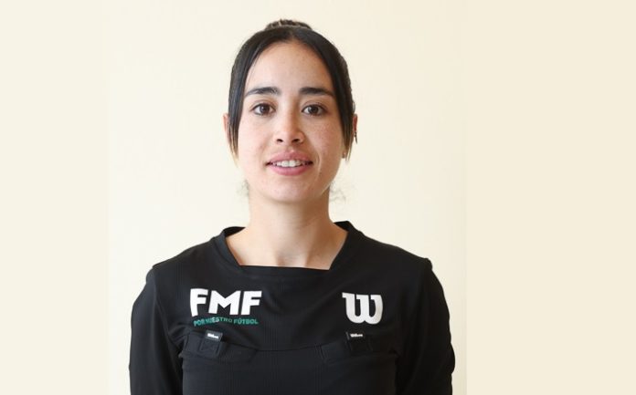 a árbitra mexicana Katia Itzel García en el Mundial portando el uniforme oficial de la FIFA dentro de la cancha de futbol.
