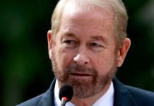 El embajador Ronald Johnson sostiene carpetas con expedientes de solicitudes de extradicion a Estados Unidos durante un encuentro oficial