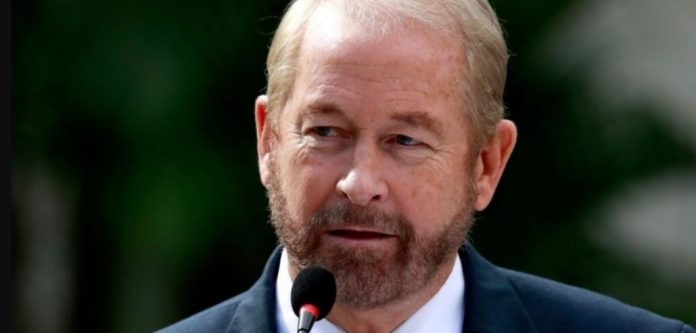 El embajador Ronald Johnson sostiene carpetas con expedientes de solicitudes de extradicion a Estados Unidos durante un encuentro oficial